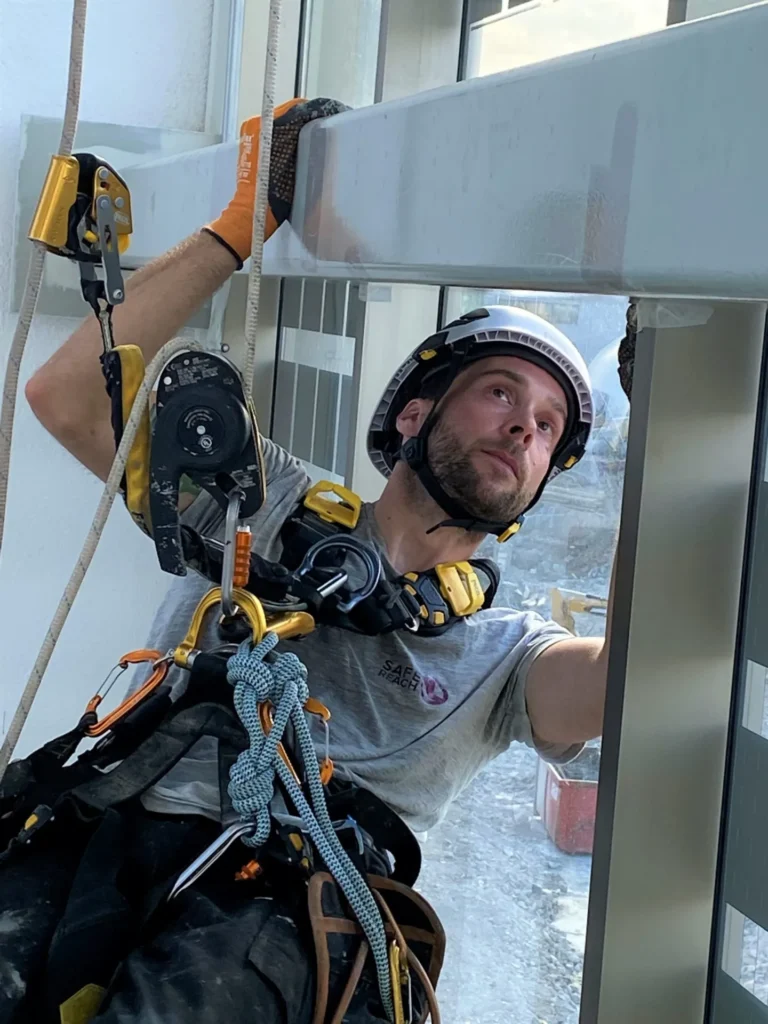En anställd på SafeReach utför arbete om en reparbetare.