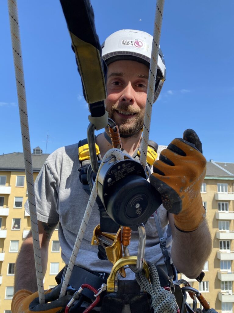 En anställd på Safereach står och ser glad ut.