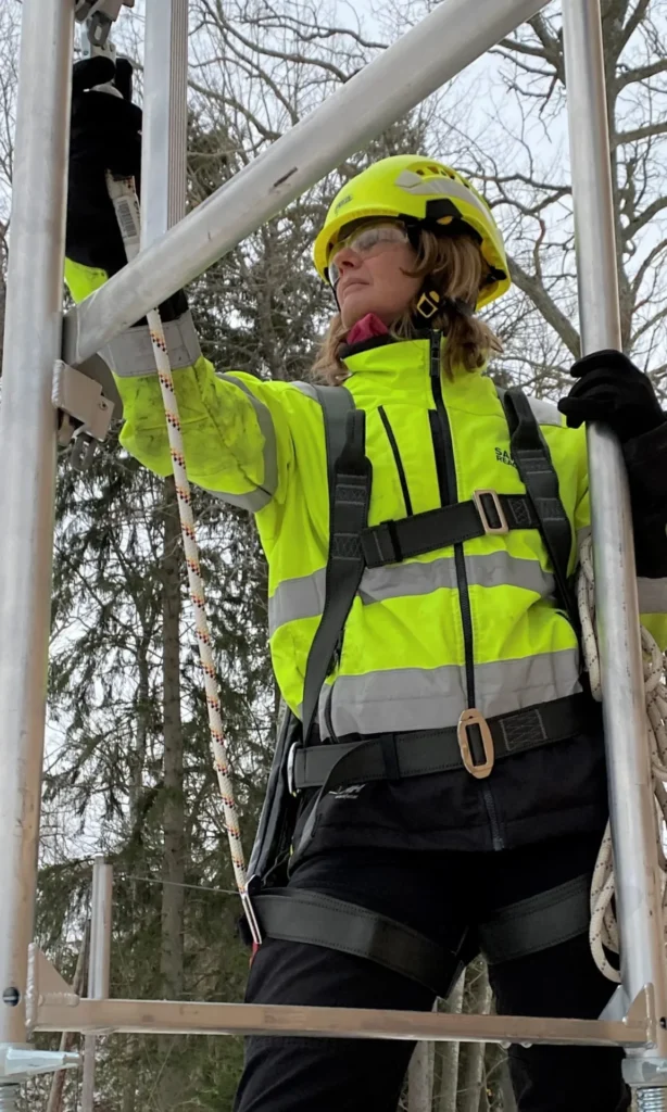 En kvinna arbetar med fallskydd på.