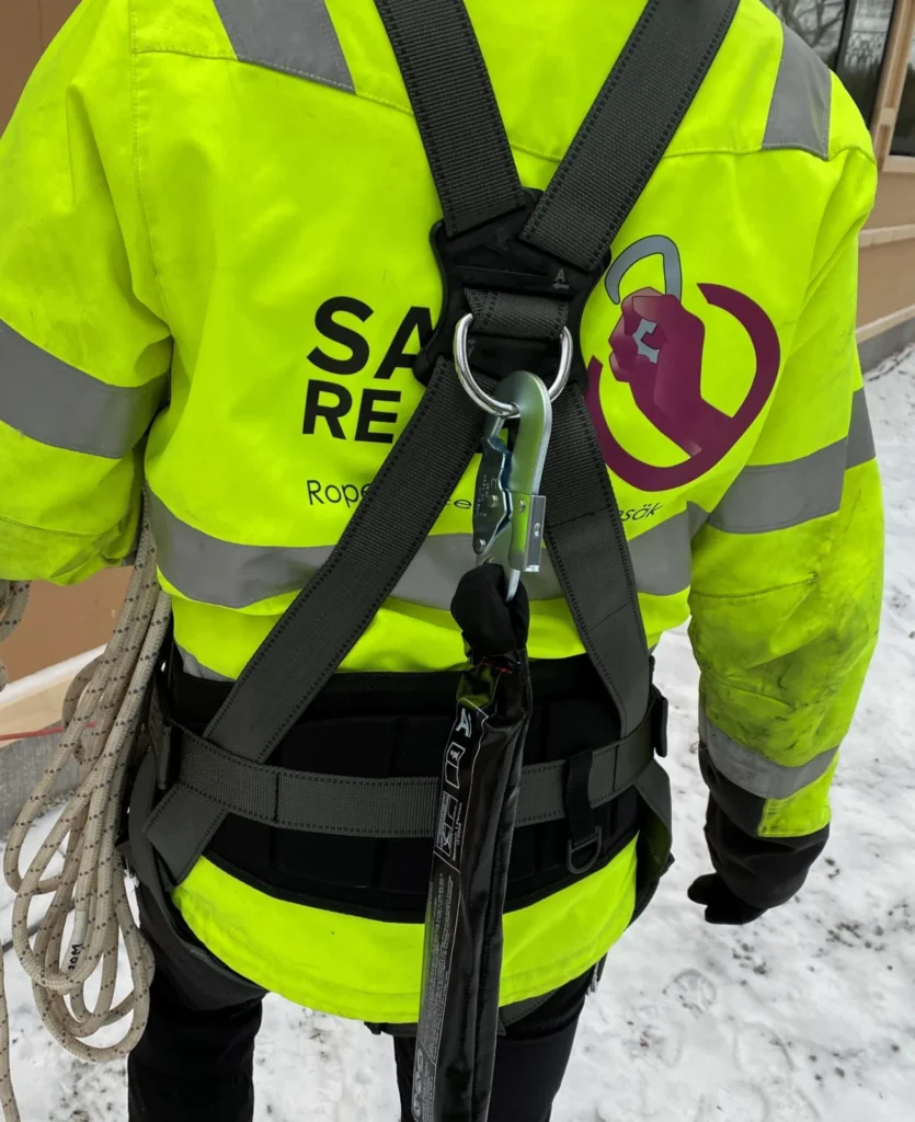 En person utrustad med fallskyddsutrustning på ryggen.